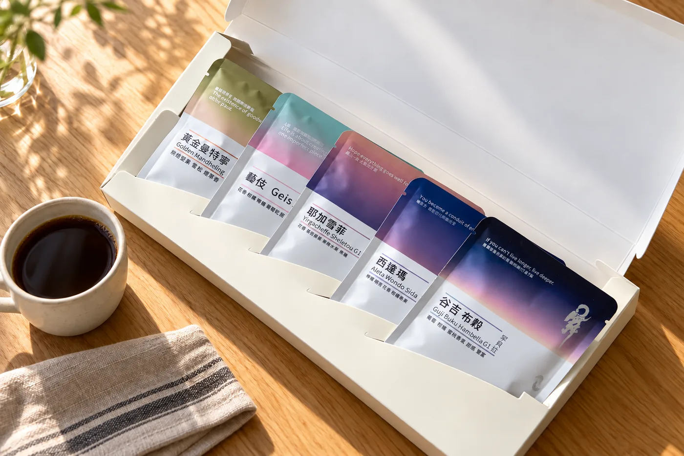 打開的五入禮盒,五包掛耳依天色排列,旁邊一杯咖啡
